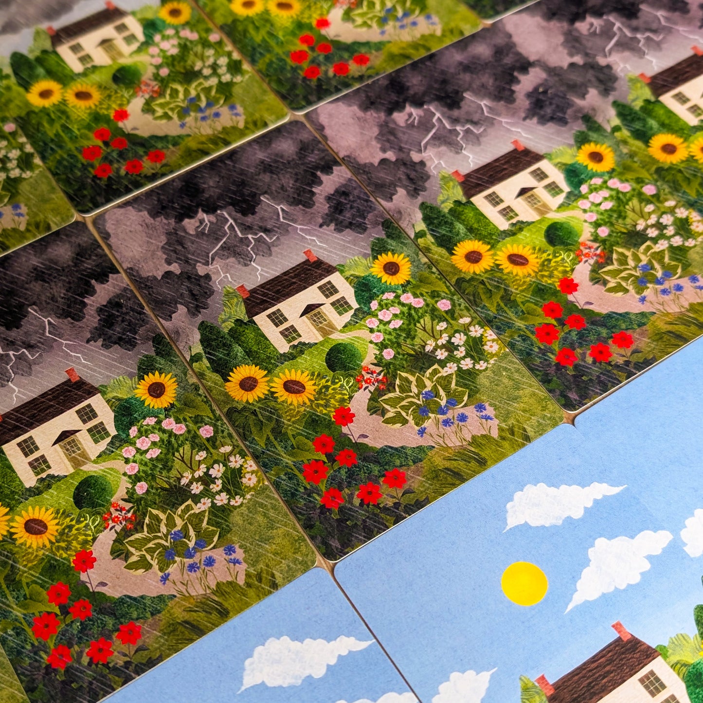 Close-up of a card with a house and garden design, surrounded by other similar tiles.