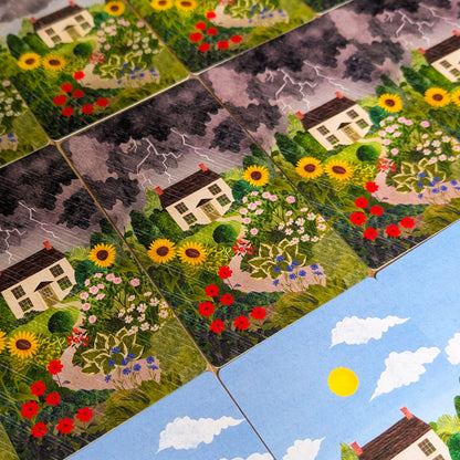Close-up of a card with a house and garden design, surrounded by other similar tiles.